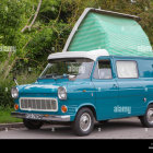 Vintage Turquoise Van with Shoe-Shaped Roof Attachment in Desert Landscape