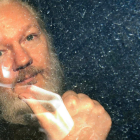 Platinum Blonde Person with Goatee Making Hand Gesture Behind Raindrop-Covered Glass