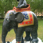 Colorful Elephant Statue with Blue Figure on Back and Decorative Patterns