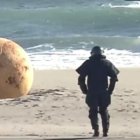 Surreal egg-shaped object with armored shell observed on beach