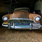 Rusted car with round headlights in dimly lit garage