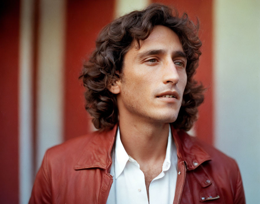 Curly Haired Man in Red Leather Jacket on Striped Background