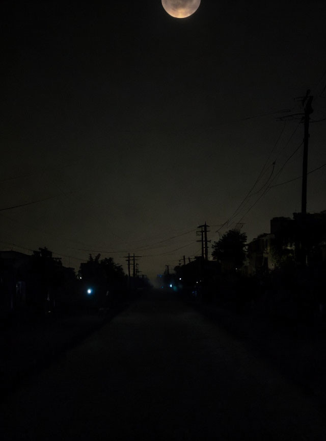 Dark Street at Night with Crescent Moon Illumination