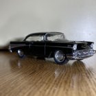Vintage Black Car with Chrome Details on Stylized White Wave Background