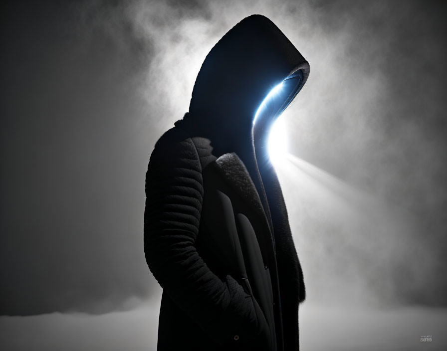 Hooded figure with glowing blue light in misty atmosphere