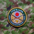 Embroidered patch with shield, star, wings, wheat, and Chinese characters on green foliage.