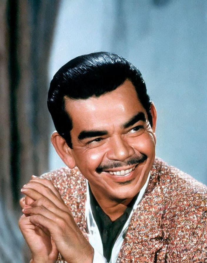 Prominent mustache man smiling in tweed jacket on blue backdrop