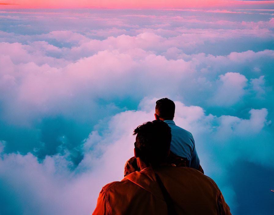 Vibrant pink and blue sunset above clouds with two people watching