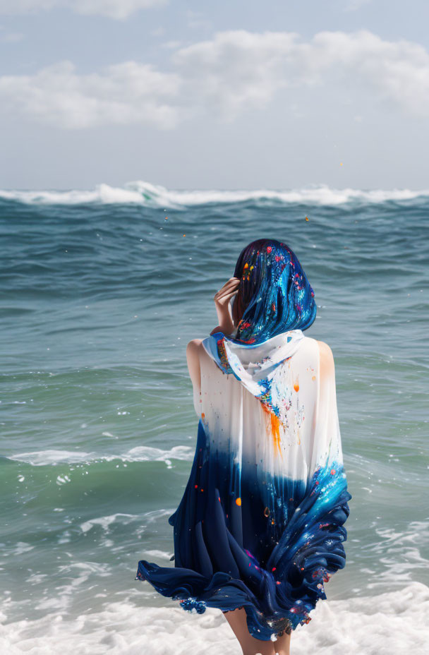Person in Blue Paint-Splattered Shawl Facing Ocean Waves