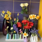 Vibrant artificial flowers in decorative vases on purple backdrop