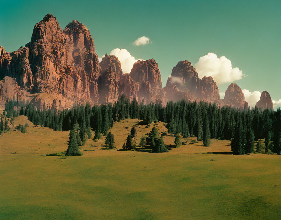 Majestic red rock formations above lush forest and meadow