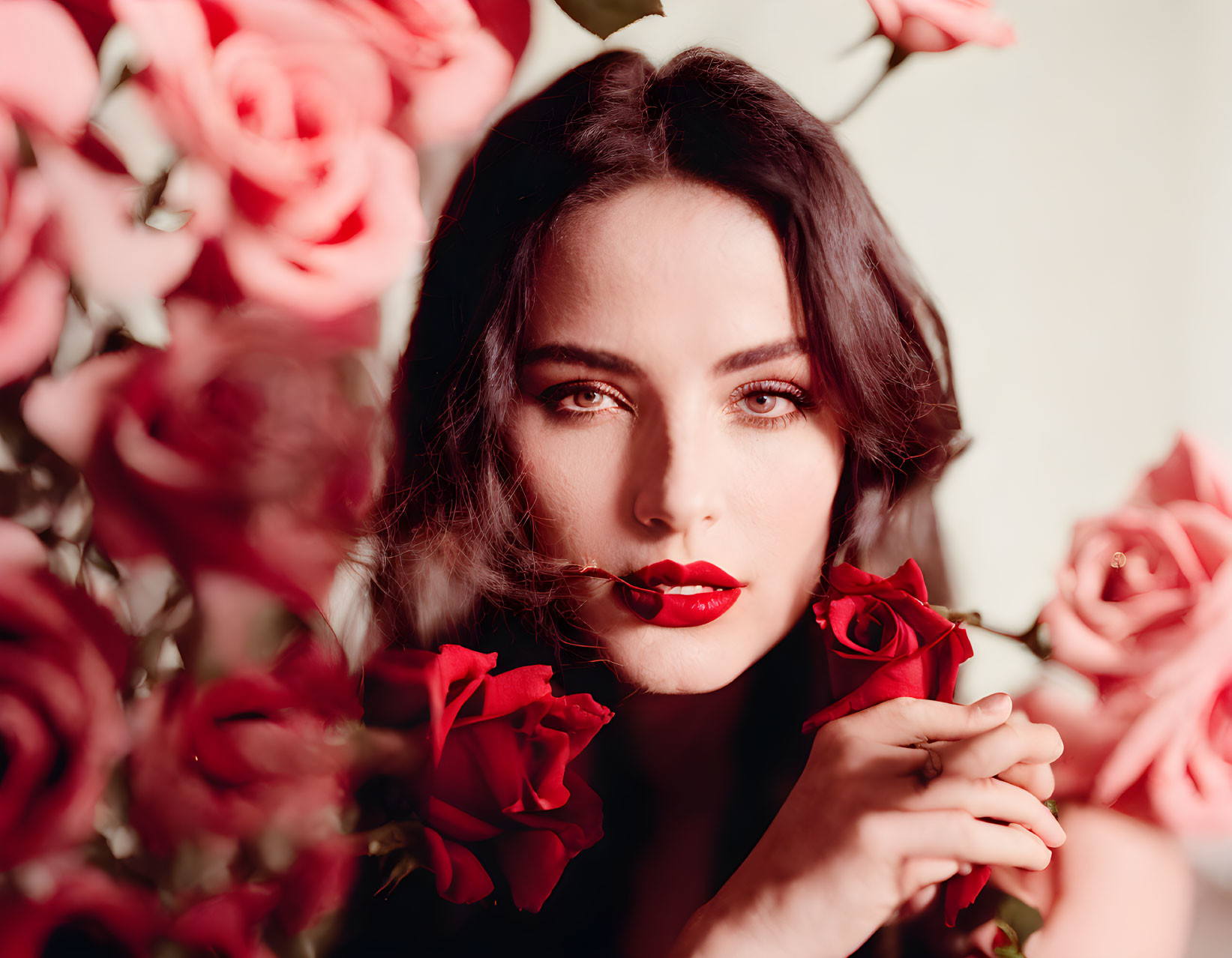 Dark-Haired Woman with Red Lipstick Surrounded by Red Roses