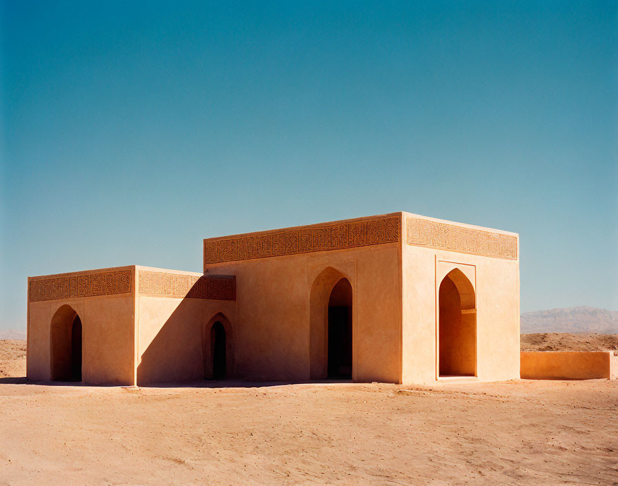 Desert architecture: simple building with arched entrances under blue sky