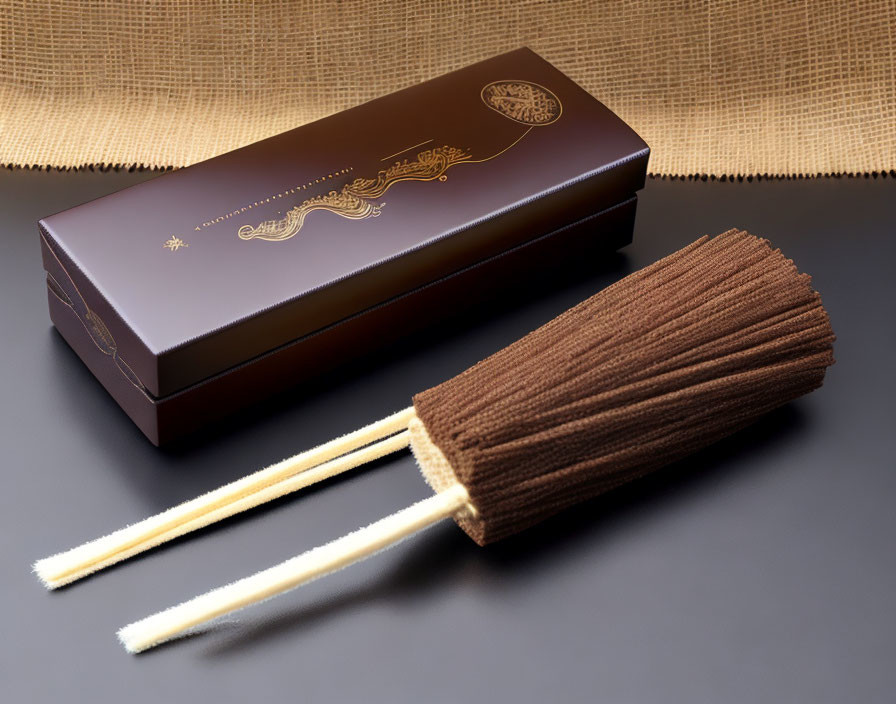 Traditional Brown Incense Sticks with Elegant Packaging on Black Surface