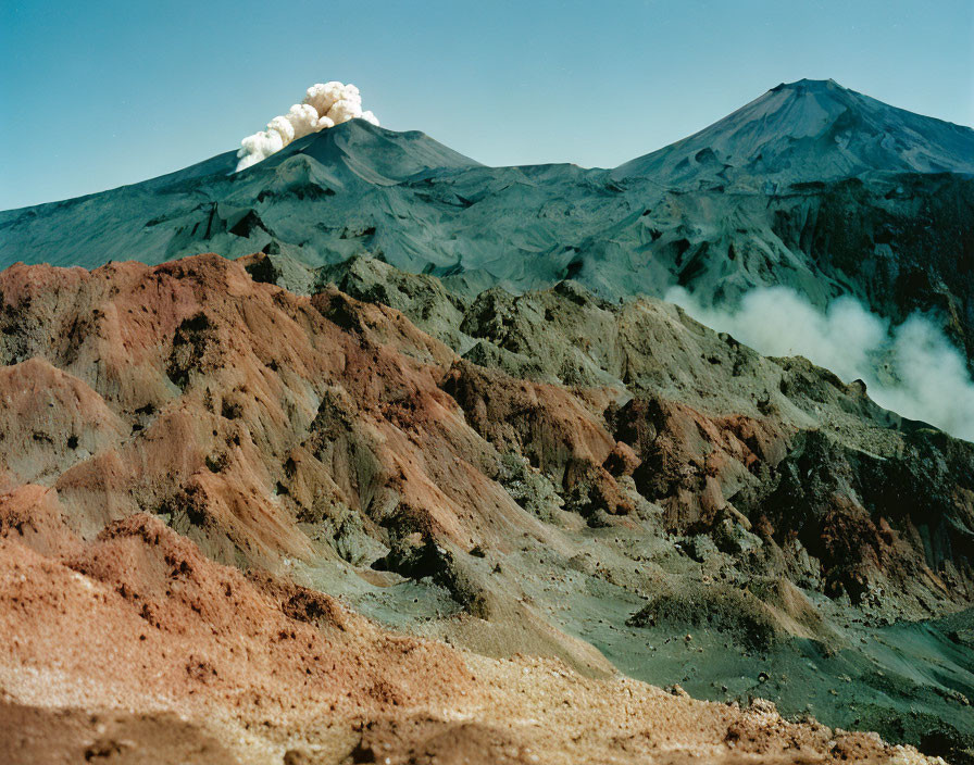 Rugged volcanic landscape with smoking volcano and colorful layers