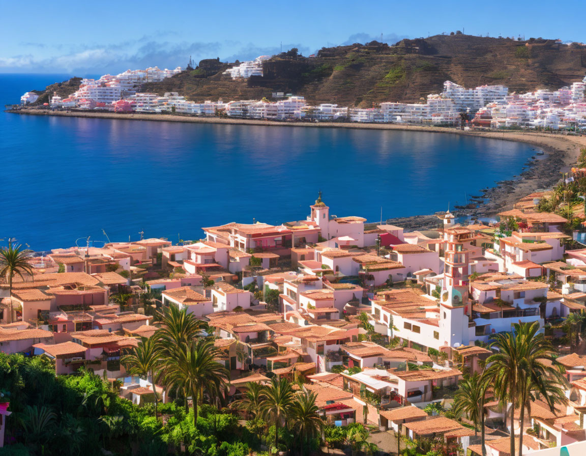 Scenic coastal town with terracotta roofs and white buildings overlooking calm blue bay