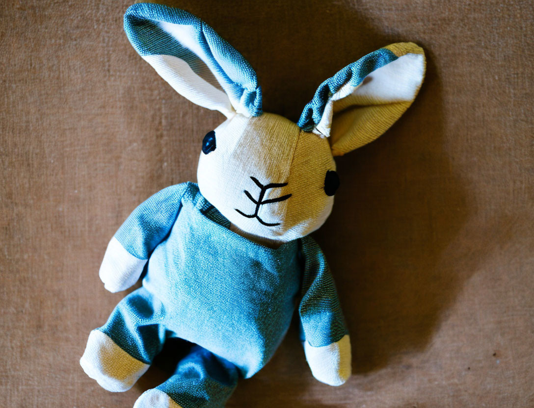 Blue and White Plush Toy Bunny on Brown Surface