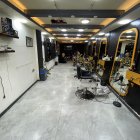 Stylish barbershop interior with leather chairs, elegant mirrors, shelves, lights, and leaf