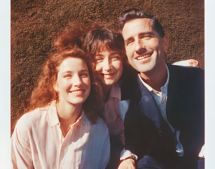 Three People Smiling Together in Bright Sunlight
