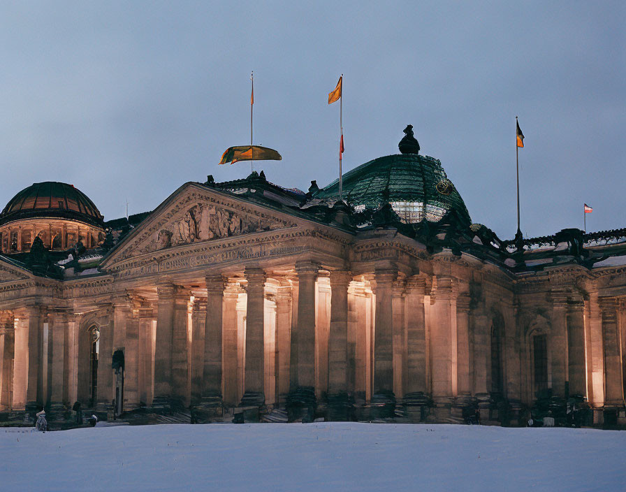 Neoclassical building with columns and dome illuminated at dusk