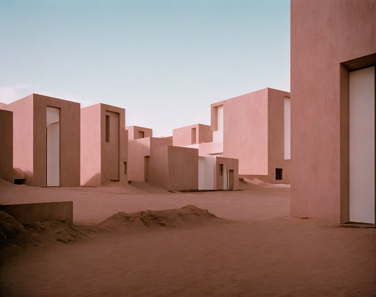 Minimalist Desert Architecture: Pink Geometric Buildings in Serene Landscape