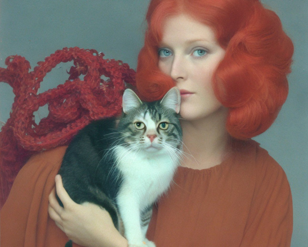 Woman with Vibrant Red Hair Holding Grey and White Cat with Red Knitted Accessory