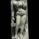 Ancient stone sculpture of female figure in contrapposto pose