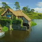 Riverside Thatched Cottages and Water Wheel in Serene Setting