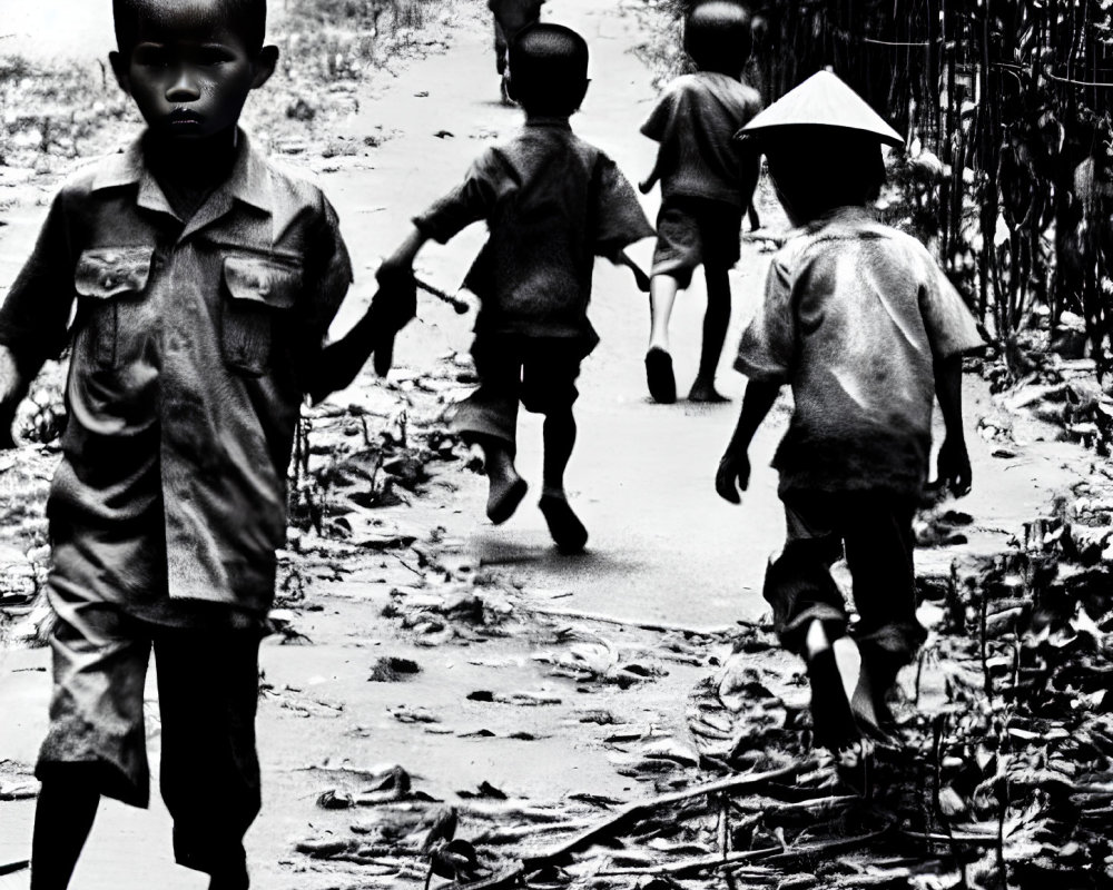 Black and white photo of five children in traditional and modern clothing walking on a path