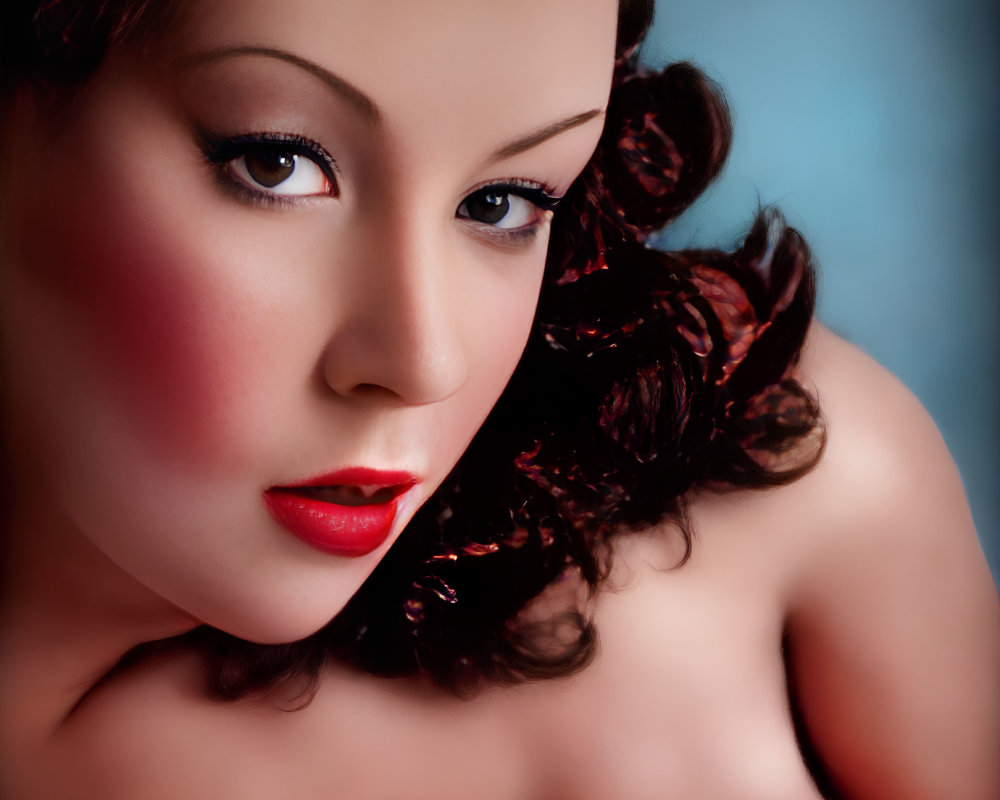 Detailed close-up of woman with red lipstick and dark curly hair on soft blue backdrop