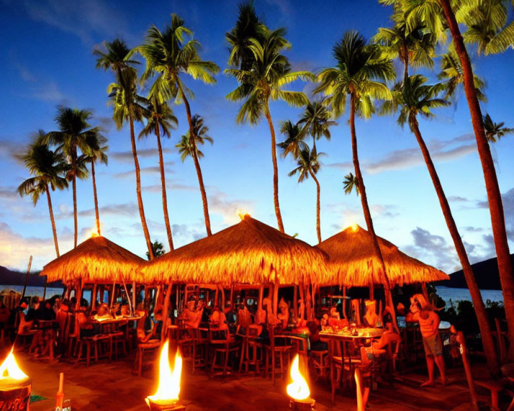 Sunset scene at tropical beach bar with thatched umbrellas, tiki torches, and palm