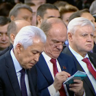 Men in Blue Suits and Red Ties with Gray Hair and Mustaches Looking at Device