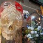 Transparent Glass Skull with Red Detailing Surrounded by Colorful Glass Objects