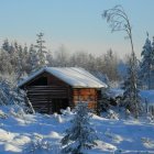 Snow-covered log cabin by gently flowing river in winter landscape