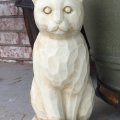 Realistic stone cat sculpture with observational eyes among rocks