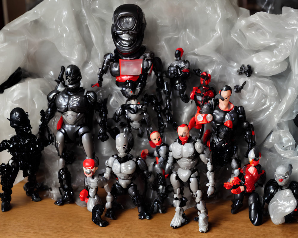 Assorted black, red, and grey action figures on wooden surface with plastic bags