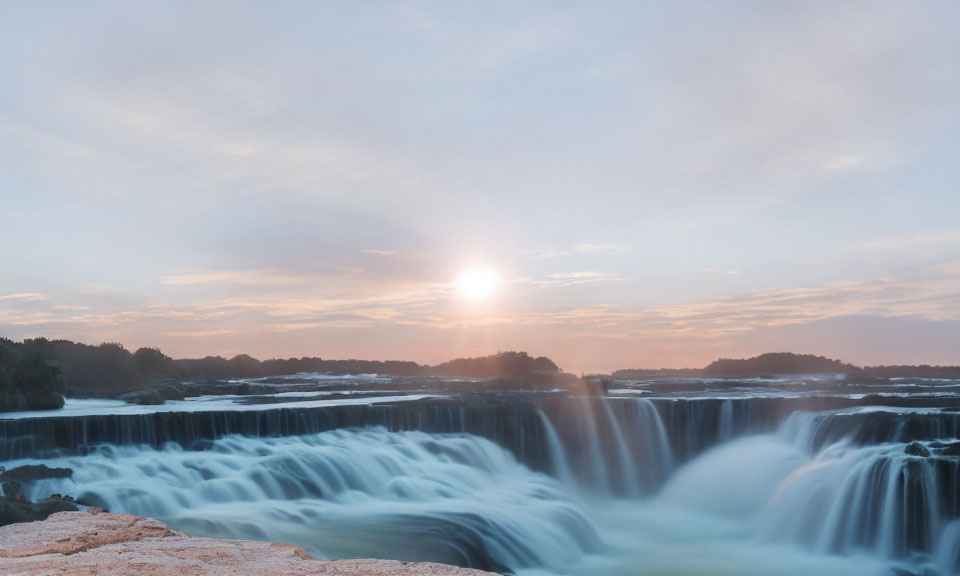 Scenic sunrise view of cascading waterfall and smooth water flow