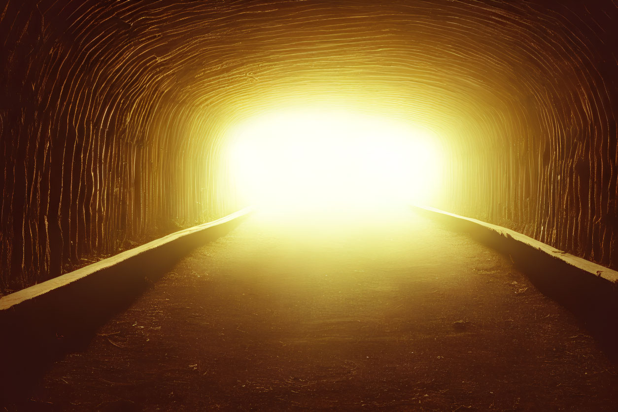 Warmly Lit Tunnel with Textured Walls and Glowing Light Creating Silhouette Effect