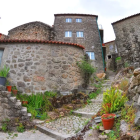 Charming village scene with half-timbered houses, flower beds, creek, rocks, and