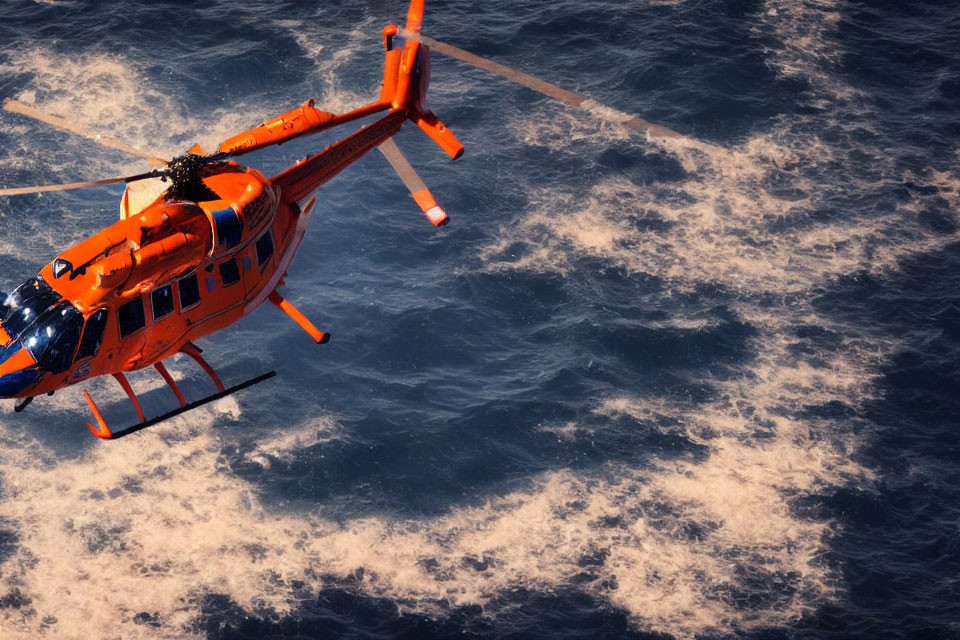 Orange Helicopter Flying Over Choppy Blue Sea Waters