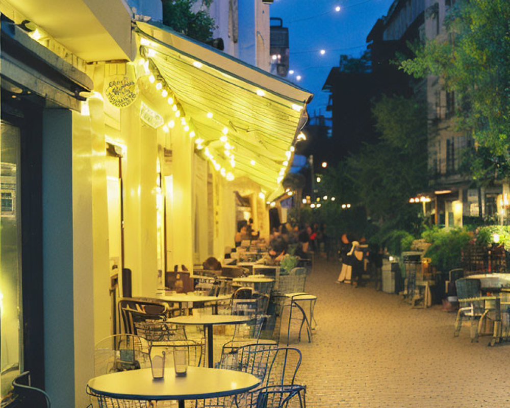 Outdoor cafe scene with string lights, empty chairs, warm shopfront glow on cobblestone street