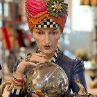Illustrated fortune teller with crystal ball and gold jewelry on sparkling background