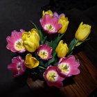 Colorful Yellow Roses and Pink Flowers on Dark Reflective Surface