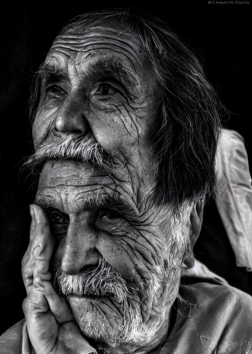 Elderly man portrait in black and white, deep wrinkles, looking pensive