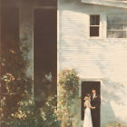 Bride and groom in doorway of old house with sunlit flowers