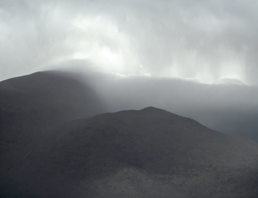 Moody landscape with dark hills under overcast sky
