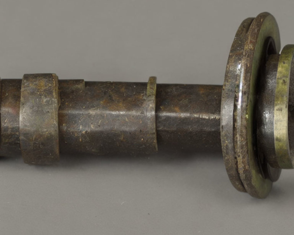 Corroded metal shaft with flanged end in close-up view