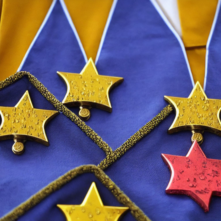 Shiny gold star-shaped medals on blue and yellow ribbon with water droplets