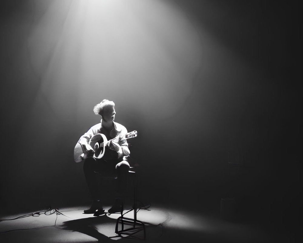 Musician Spotlighted Playing Acoustic Guitar Solo in Dramatic Lighting