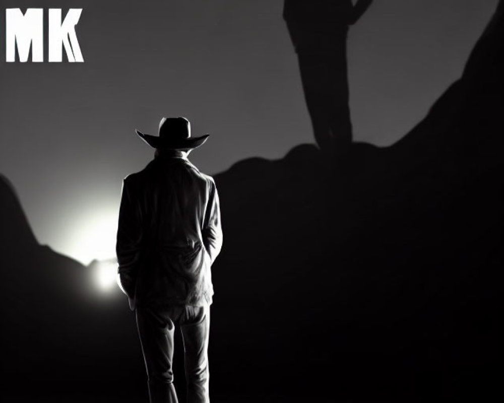 Silhouetted figure in hat with monumental shadow on mountain, "NSN MK" letters above